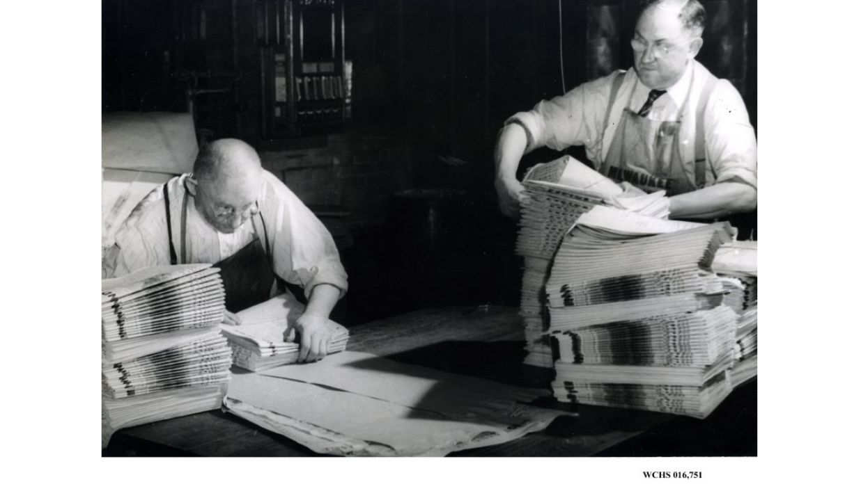 Newspaper employees bundling papers in 1929 in Washington County, Wisconsin